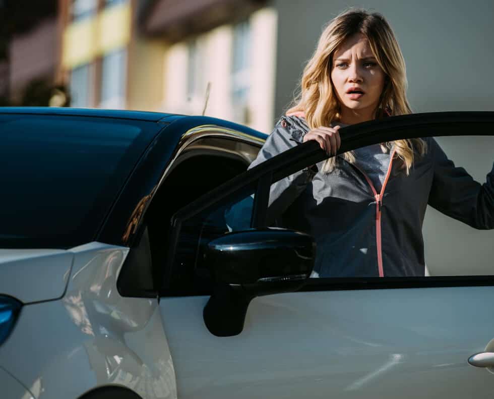woman next to her car looking at something